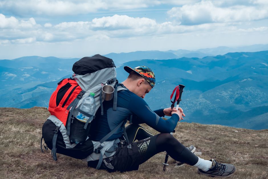 Man resting with backpack on a mountain top in Zakarpattia Oblast, Ukraine. Outdoor adventure.