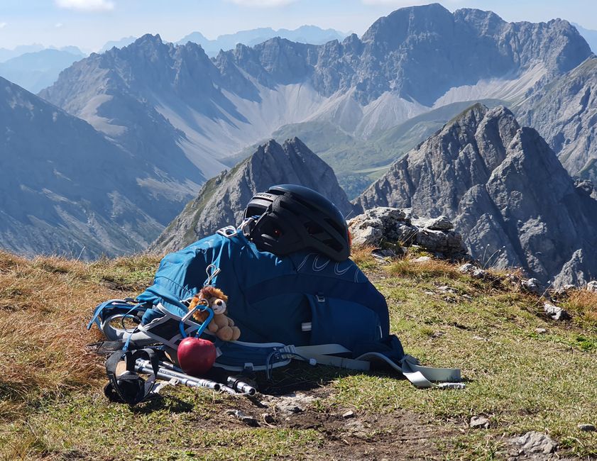 Backpack and hiking gear on a mountain peak providing an adventurous landscape view.