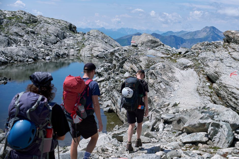 Adventurous hikers traverse rocky alpine paths in the Austrian Alps.